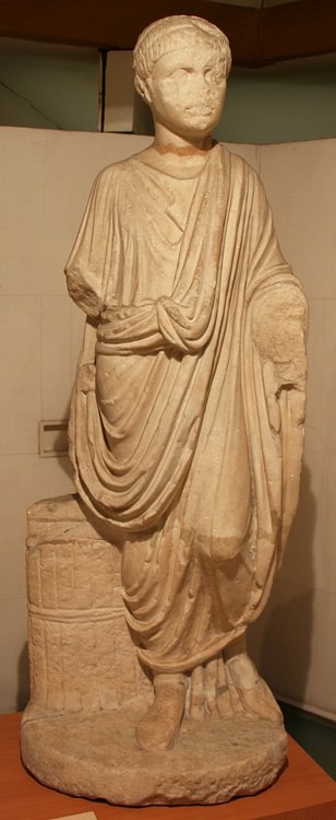 Statue of a Man Wearing a Toga beside a Capsa